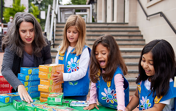 girl scout selling cookies with parent